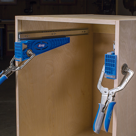 The Drawer Slide Jig consists of two brackets that clamp in place inside the cabinet one on each cabinet side