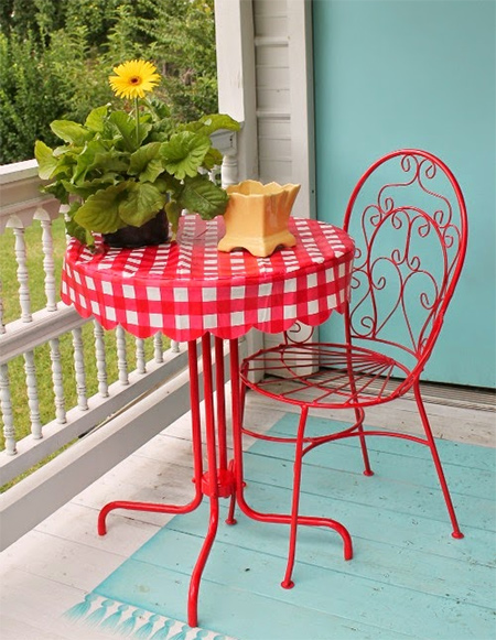 Left out in the trash, this bistro table and chair gets repurposed and upcycled with Rust-Oleum gloss apple red and a vinyl tablecloth.