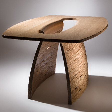 Inspired by naturally occurring geometric forms, John Lee explores the enhancement of timber’s natural properties whilst experimenting with form, function and finish. Lee's designs explore textured finishes by working the natural grain patterns of raw timber into his dynamic forms. The 'Pegasus Table' is solid oak with a hand carved base. 