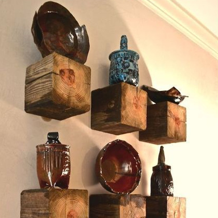 Reclaimed fence posts or wood beams are cut down to size to make wood shelves to display a variety of collectibles.