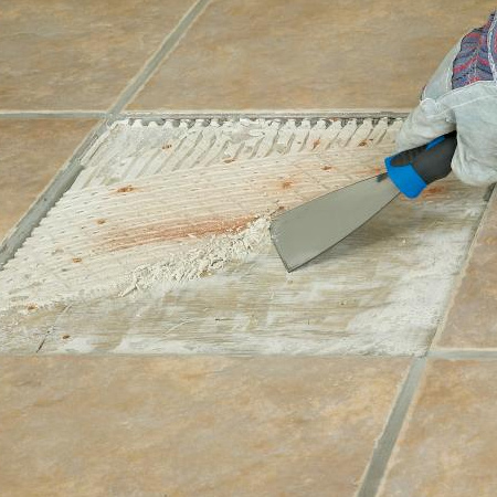 4. Use a paint scraper to remove any hardened old adhesive off the floor. Hard areas can be gently tapped with the hammer and chisel to loosen.