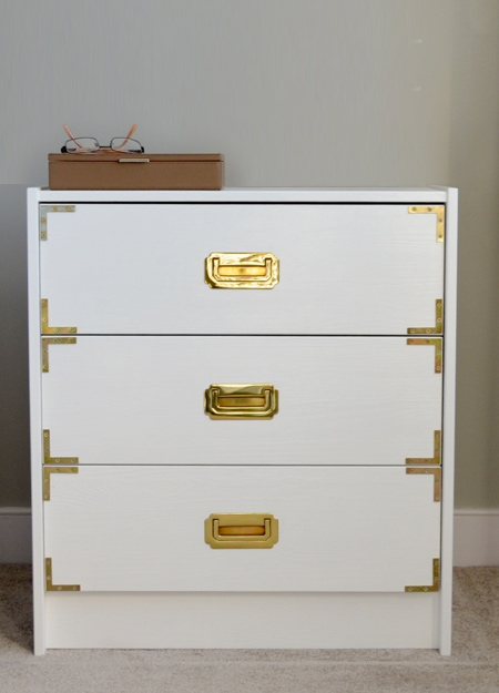 Sometimes all it takes is a coat or two of paint, new handles, and adding brass corners onto drawer fronts. If you are unable to find brass corners, use steel corners and apply a coat of Rust-Oleum metallics brass spray paint.