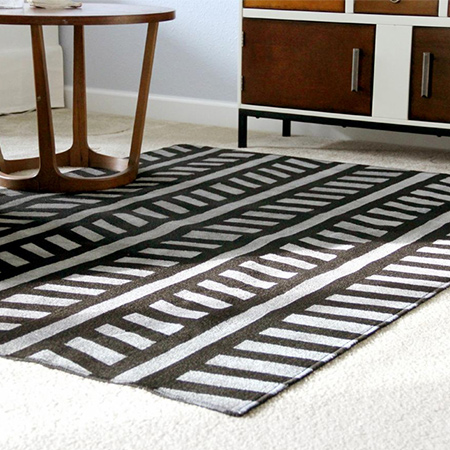 Here's an easy way to add a new look to a plain, expensive low-pile, coir, sisal or jute rug. All you need is some paint and masking tape!