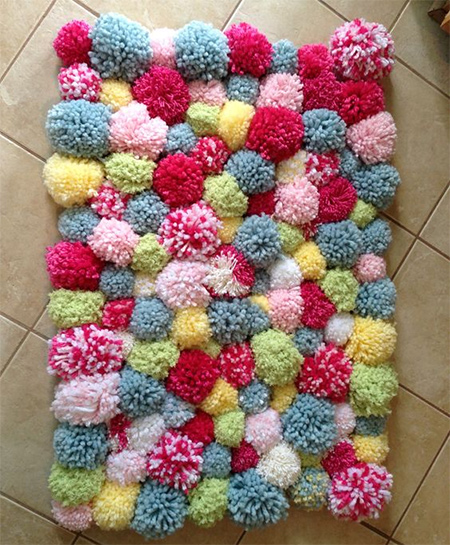 make up a batch of colourful pom-poms and attach these onto a woven mat.