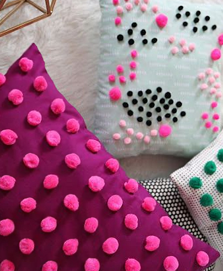 Pom-poms small or large add colour, interest and texture to plain cushions
