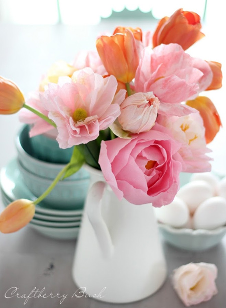 Use crepe paper flowers to add a splash of colour to your dining table. This assorted display of palest pink crepe paper flowers adds interest to a few tulips.  