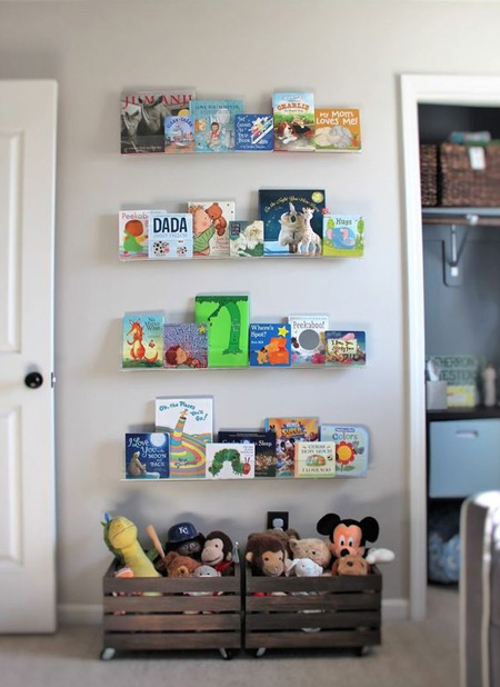 Acrylic or plexiglass storage boxes secured onto the wall with double-sided table make a pretty display for a child's bedroom. Arrange books according to age, so that books for reading now are at the bottom and can be easily rotated as your child grows.