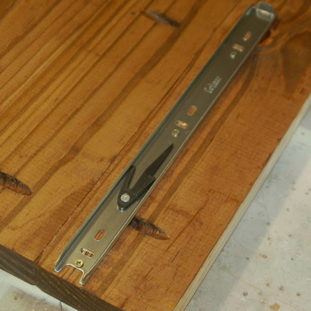 12. Measure and mark at 54mm up from the top and bottom edge of both tops. Separate the runner and place the frame side centrally on this mark and secure with 13mm screws.