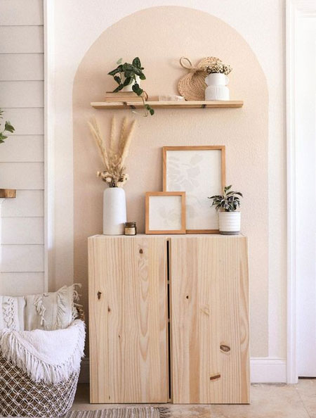 pink wall arch above wood cabinet
